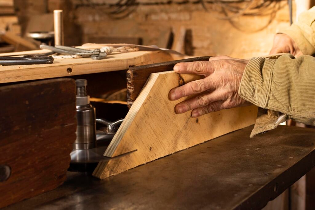 Carpenter shaping a timber component at a workshop machine