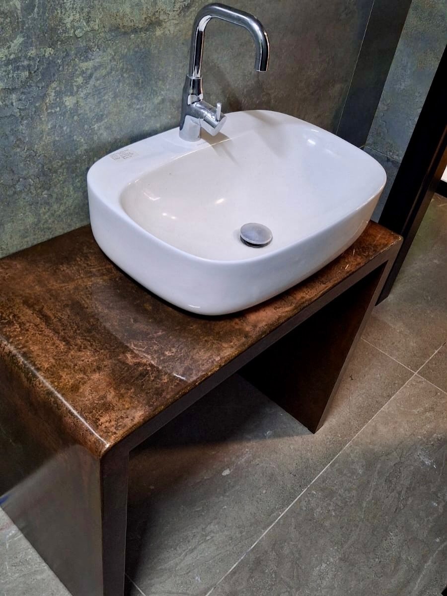 Handcrafted rust-effect basin stand with a white sink by Artifex
