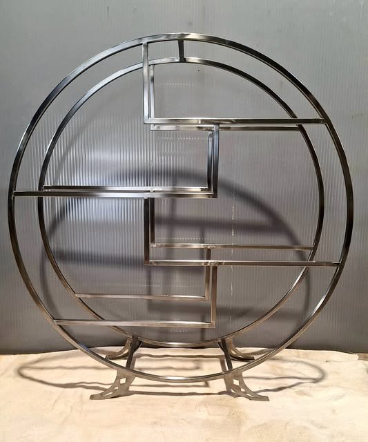 Circular metal shelving unit with geometric shelves
