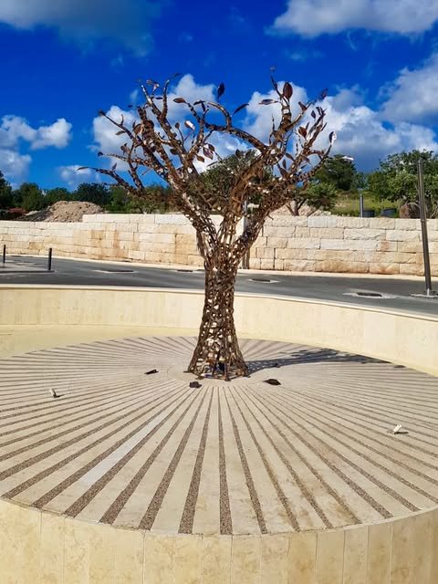 Sculptural metal tree installed in an outdoor public space