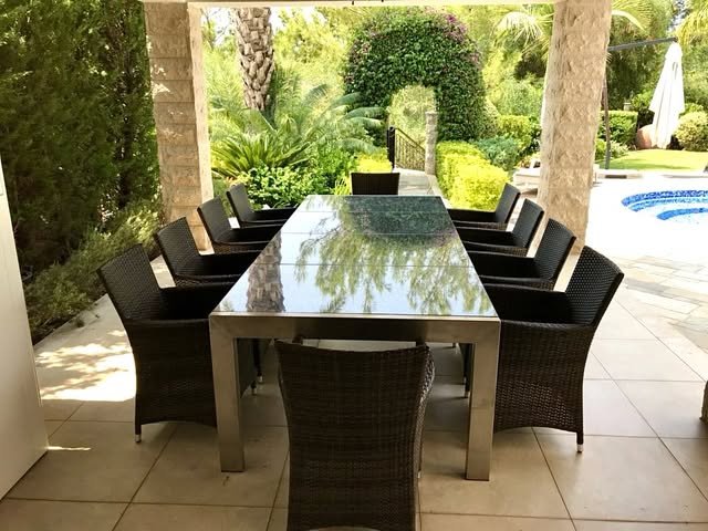 Outdoor dining table on a covered terrace overlooking a garden