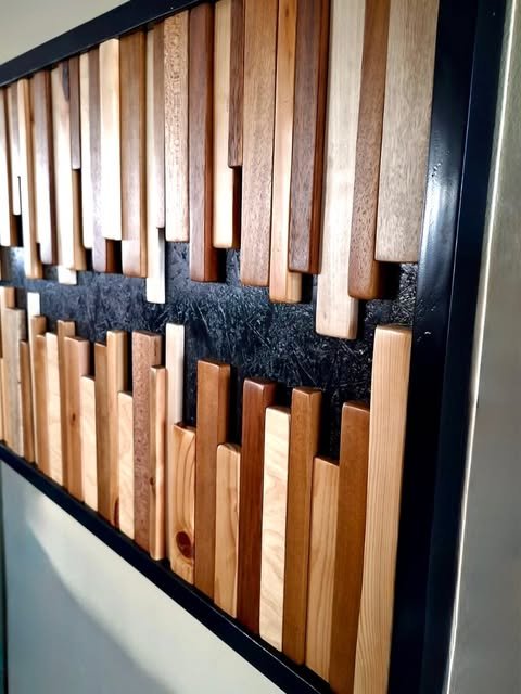 Sculptural timber strips arranged on a dark wall panel